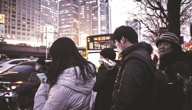Commuters using smartphones stand in line at a bus station in Beijing. Now China is the worldu2019s second-largest economy, set to overtake the US in around a decade, while India will be the worldu2019s most populous nation by 2022.