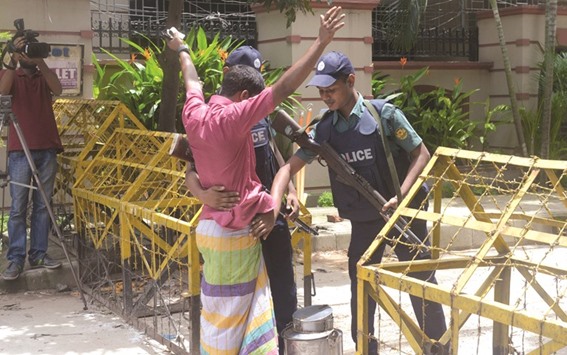 Policemen frisking a man near the restaurant where the militant attack took place in Dhaka yesterday. After a video where three Bangla-speaking men are seen commending Dhakau2019s cafe attackers and threatening more attacks in Bangladesh went viral on social media, Bangladesh police has warned of stern action against those sharing any such content which indulges militant activity.