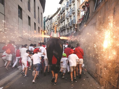 A man dressed as a u2018Toro de Fuegou2019 (bull of fire) chases people during the San Fermin Festival in Pamplona.