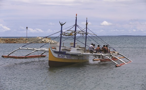 Fishermen take a break after returning from a fishing trip in the South China Sea, on the shores of Infanta town, Pangasinan province, northwest of Manila.