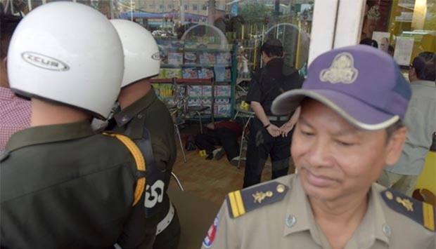 Cambodian police officials stand guard near the body of independent political and social analyst Kem Ley after he was shot dead at a convenience store in Phnom Penh on Sunday.