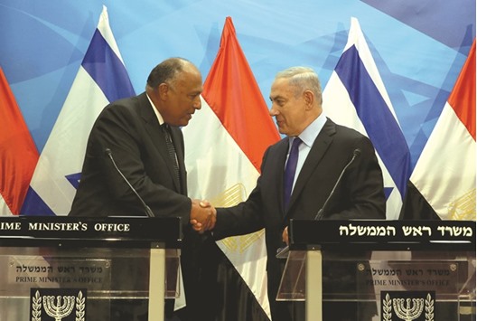 Israeli Prime Minister Benjamin Netanyahu  shakes hands with Egyptian Foreign Minister Sameh Shoukry after giving a joint statement prior to their meeting at his Jerusalem office yesterday. Shoukry met Netanyahu in Jerusalem for talks on reviving peace efforts with the Palestinians, in the first such visit in nearly a decade and the latest sign of warming ties.