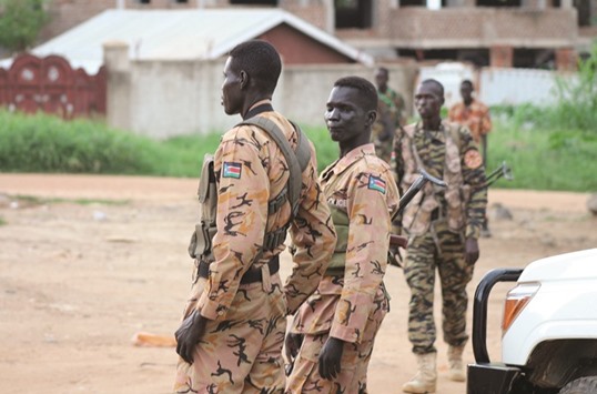 South Sudanese policemen and soldiers stand guard along a street following renewed fighting in South Sudanu2019s capital Juba, yesterday.