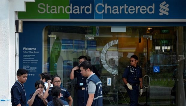 Police officers work at scene of a robbery at Standard Chartered Bank branch in Holland Village, Singapore.