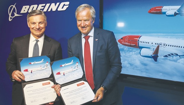 Ray Conner, CEO of Boeingu2019s commercial aircraft unit (left), and Bjoern Kjos, CEO of Norwegian Air Shuttle, pose for photographs following the signing of a strategic support agreement on the opening day of the International Airshow 2016 in Farnborough. Boeing and Airbus, the worldu2019s two biggest plane makers, announced a flurry of multi-billion dollar jet deals at the biennial airshow, which opened yesterday.