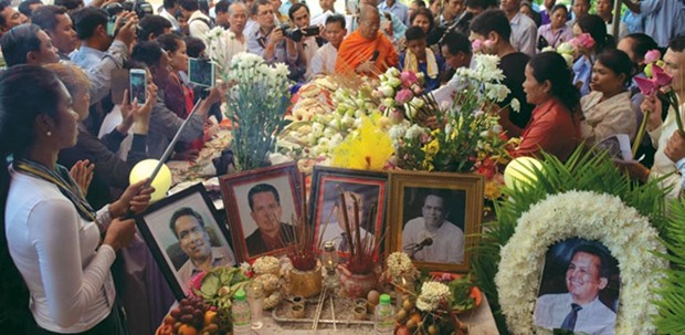 Cambodians pay their respects during a funeral ceremony for political analyst Kem Ley at a pagoda in Phnom Penh yesterday.