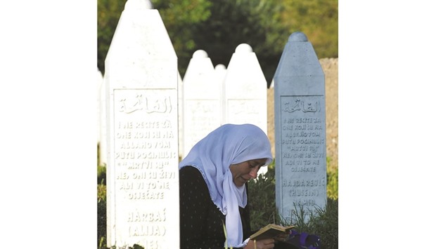 A Bosnian Muslim survivor of the 1995 Srebrenica massacre mourns near graves of her relatives at memorial cemetery in Potocari, near the eastern Bosnian town of Srebrenica.