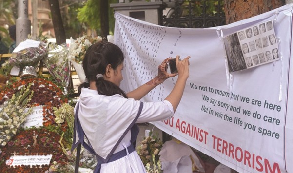 A schoolgirl taking video near the restaurant where the militant attack took place in Dhaka.