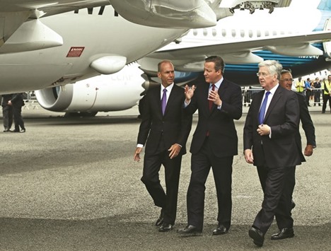 Prime Minister David Cameron and Defence Secretary Michael Fallon speak to Boeing chief executive officer Dennis Muilenburg on the opening day of the Farnborough Airshow, south west of London, yesterday.