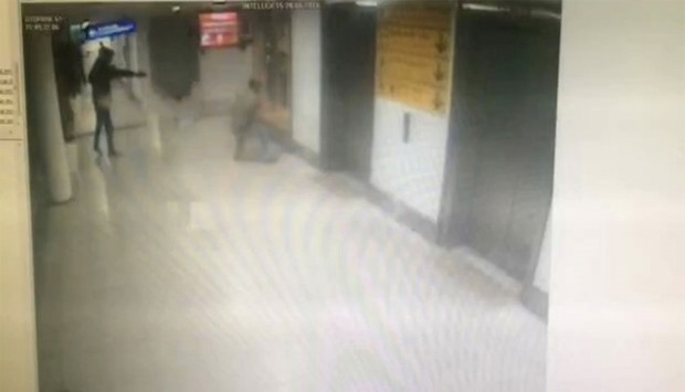 In this frame-grab from CCTV video, made available by Turkish police, a man (L) believed to be one of the attackers, uses a firegun against a Turkish police after being asked his id card at Istanbul Ataturk airport on June 28, 2016. AFP  / Istanbul police headquarters