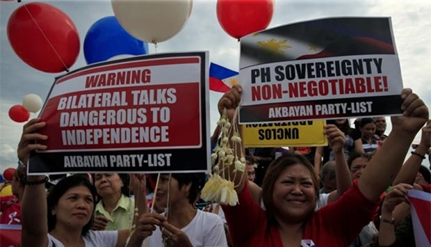Protesters display placards during a rally by different activist groups over the South China Sea dispute, along a bay in metro Manila on Tuesday.