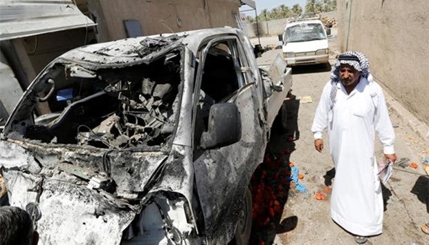 A man walks past the site of a car bomb attack in Rashidiya, north of Baghdad, on Tuesday.