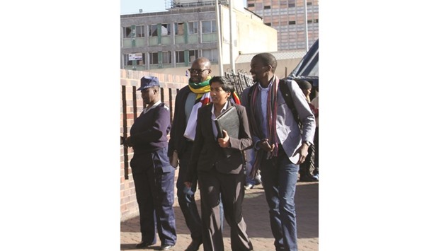 Zimbabwean pastor Evan Mawarire, second left, who organised a u2018stay at homeu2019 anti-government protest last week, arriving at the Harare Central Police station yesterday.