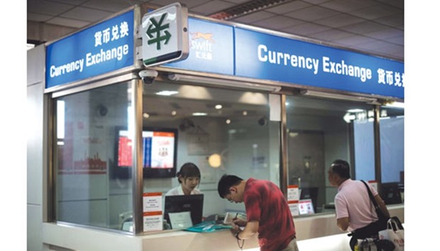 A man changes foreign currency into Chinese yuan at a currency exchange office in Hongqiao airport in Shanghai. The yuan has slid 1.6% since Britainu2019s June 23 vote to quit the European Union.