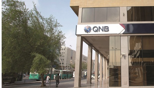 Pedestrians pass a QNB branch in Doha. The banku2019s total assets increased by 36% from June 2015 to reach QR692bn, the highest ever achieved by the group.