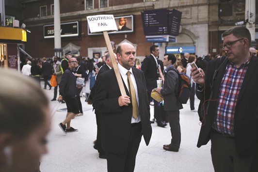 A man takes part in a protest at Victoria Station against train operator Southern railu2019s planned timetable cut.