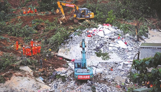 Rescue workers carry out a search at the scene of a landslide that left at least one dead and 20 missing in Bijie, Guizhou province.