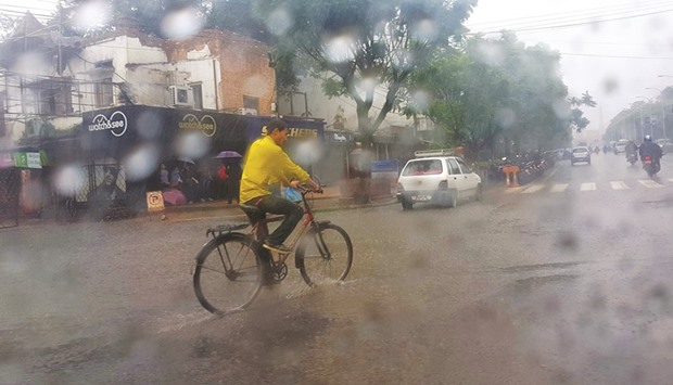 A man riding a bicycle in the rain in Kathmandu yesterday. Nepal has been witnessing heavy rainfalls and landslides in various parts of the country.