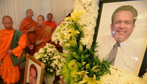 Buddhist monks walk past portraits of Kem Ley during a funeral ceremony in Phnom Penh.