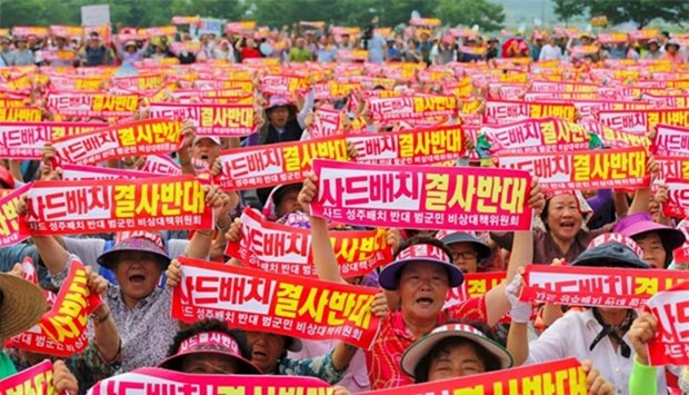 Thousands of South Korean residents hold up red banners reading ,We absolutely oppose THAAD deployment,, during a rally againt the planned deployment of the US-built Terminal High Altitude Area Defence, in Seongju town, 217 km southeast of Seoul, on Wednesday.