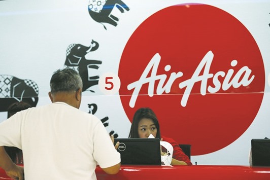 A passenger waits to check in at AirAsia counters for a flight at Don Muang International Airport in Bangkok. AirAsia carried 50.7mn people last year, 11% more than in 2014. The low-cost carrier had 170 planes in its fleet at the end of March.
