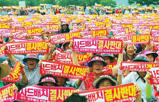 South Koreans hold up red banners reading u201cWe absolutely oppose THAAD deploymentu201d, during a rally against the planned deployment of the US-built Terminal High Altitude Area Defense, THAAD, in Seongju town.