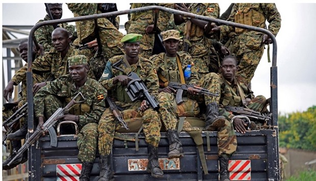 Uganda People's Defence Forces (UPDF) soldiers ride atop their military truck enroute to evacuate their citizens following recent fighting in Juba at Nimule town along the South Sudan and Uganda border.