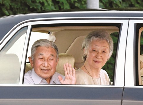 Japanu2019s Emperor Akihito waves to well-wishers as they leave the imperial villa in Hayama town, Kanagawa prefecture, as Empress Michiko looks on.