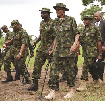 Former military ruler President Mohammadu Buhari (right) walks accompanied by service chiefs and other senior military officers during the Army Day celebration in Dansadau, northwest Nigerian Zamfara State, on Wednesday.