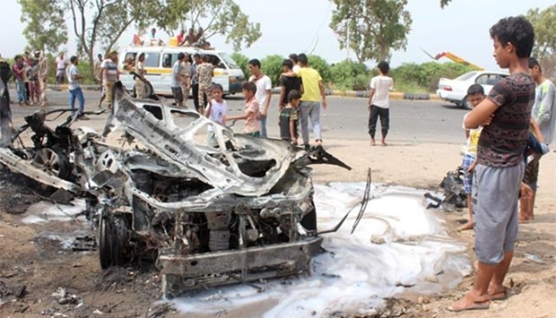 Yemenis inspect a charred vehicle following a suicide car bombing attack that targeted the convoy of Aden's governor on Friday.