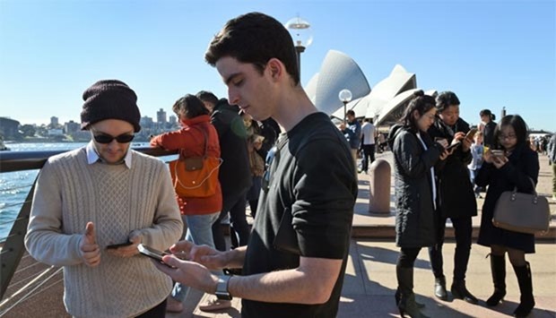 Dozens of people gather to play Pokemon Go in front of the Sydney Opera House on Friday.