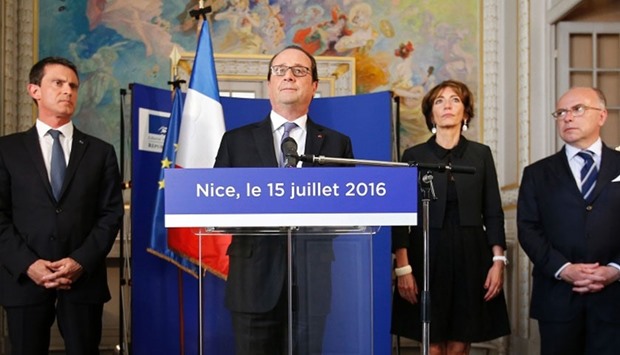 French President Francois Hollande (2nd L) stands with Prime Minister Manuel Valls (L), Interior Minister Bernard Cazeneuve (R) and Minister of Health Marisol Touraine (2nd R) as he speaks to journalists at the Prefectoral Palace the day after a gunman smashed a truck into a crowd of revellers celebrating Bastille Day in Nice, killing at least 84 people.