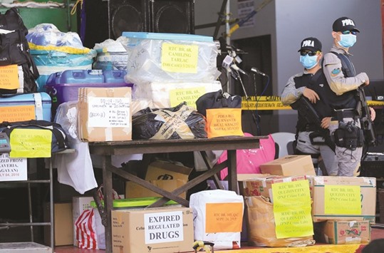 Members of Philippine Drug Enforcement Agency (PDEA) stand guard besides confiscated illegal drugs such as methamphetamine hydrochloride, referred to as Shabu, cocaine, marijuana, ephedrine, ketamine, pseudoephedrine and expired medicines, during the destruction of illegal drugs at a waste management facility in Trece Martires town, Cavite, south of Manila on Thursday.
