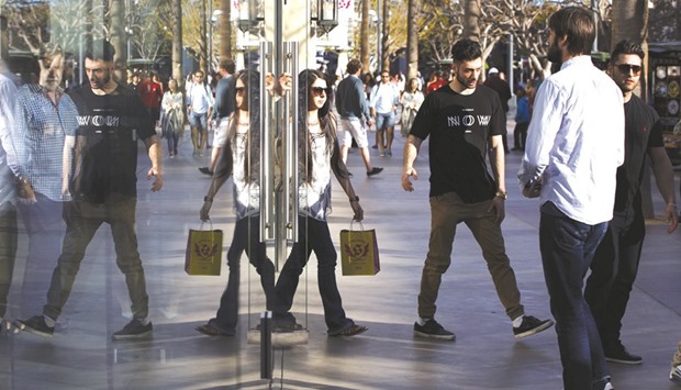 Shoppers are reflected in the window of a store at the Third Street Promenade in Santa Monica, California. US retail sales rose more than expected in June as Americans bought motor vehicles and a variety of other goods, reinforcing views that economic growth picked up in the second quarter.