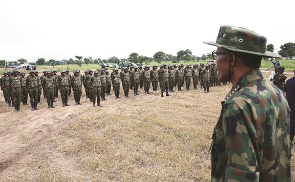 President Buhari stands in front of soldiers as he waits for their salute during the Army Day celebration in Dansadau, northwest Nigerian Zamfara State, on Wednesday.