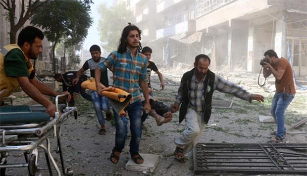 Syrians and rescuers evacuate a wounded person following reported air strikes on Saturday in the rebel-controlled neighbourhood of Saleheen in Aleppo.