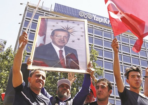 Supporters of Erdogan lift up his portrait as they celebrate the failure of the coup bid in Ankara.