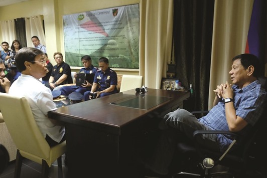 President Rodrigo Duterte (right) speaks with businessman Peter Lim (L) during a meeting at the Philippine Drug Enforcement Agency (PDEA) office in Davao City, on the southern island of Mindanao.