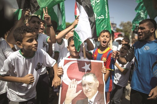 Palestinian supporters of Hamas hold portraits of Turkish President Recep Tayyip Erdogan as they shout slogans against the military coup attempt in Turkey, during a demonstration in Gaza City, yesterday.
