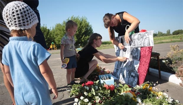 Local villagers place pictures of the passengers of MH17 flight at a makeshift memorial in Petropavlivka village, Donetsk region, on the second anniversary of the tragedy on Sunday.