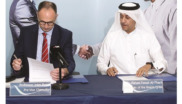 Northumbria Universityu2019s Professor Jon Reast, pro vice-chancellor (International) signs the MoU while QFBA chairman Sheikh Fahad Faisal al-Thani looks on.