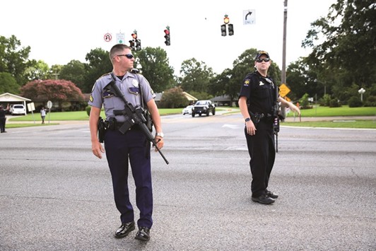 Police officers block off a road near the site of a shooting of police in Baton Rouge yesterday.