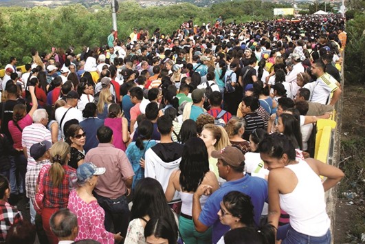 People cross over the Simon Bolivar international bridge to Colombia to take advantage of the temporary border opening in San Antonio del Tachira, Venezuela, yesterday.