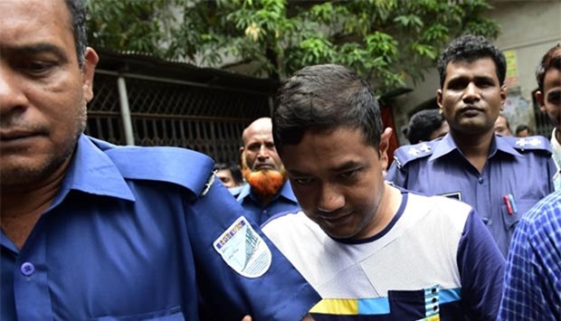 The owner of the collapsed Rana Plaza building Sohel Rana is escorted by security personnel ahead of an appearance at a court in Dhaka in this file photo.