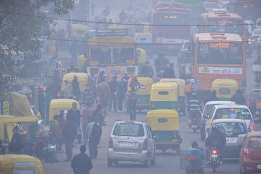 Commuters travel on a polluted road near a bus terminus in the Anand Vihar District of New Delhi. The National Green Tribunal yesterday ordered all diesel vehicles older than 10 years be deregistered.