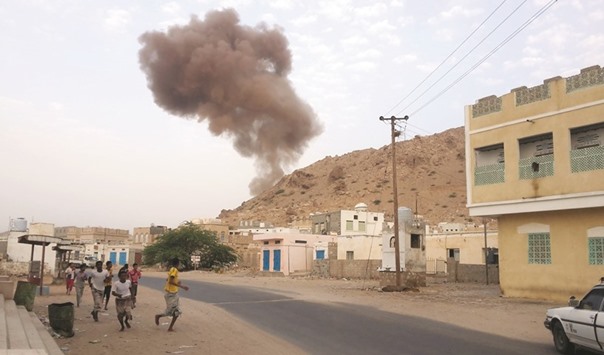 Yemenis run for cover as smoke rises following a car bomb attack at an army checkpoint at the entrance to the town of Hajr, located some 15km to the west of Mukalla, the capital of Yemenu2019s southeastern Hadramawt province yesterday. Suicide bombers attacked two army checkpoints in a former stronghold of Al Qaeda in southeastern Yemen, killing 11 people.
