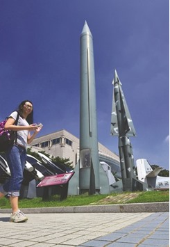 A woman walks past replicas of a North Korean Scud-B missile (centre) and South Korean Nike missile (right) at the Korean War Memorial in Seoul. North Korea test-fired three ballistic missiles yesterday, South Koreau2019s military said, just over a week after issuing threats to respond to the planned deployment of a US anti-missile system in the South.