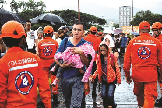 Colombia civil defence personnel help people cross the Colombian-Venezuela border over the Simon Bolivar international bridge in Cucuta, Colombia.