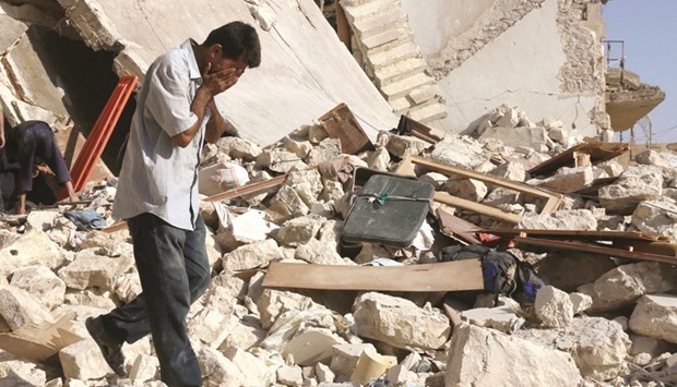 A Syrian man reacts as rescuers look for victims under the rubble of a collapsed building following a reported air strike on the rebel-held neighbourhood of Al-Tukhar in the northern city of Aleppo yesterday.