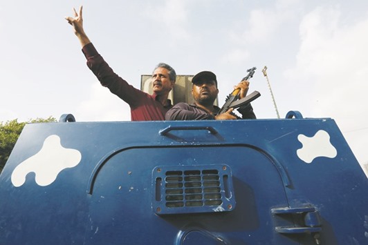 Waseem Akhtar, mayor nominee of Muttahida Qaumi Movement (MQM), gestures from an armoured personal carrier while being taken to jail after his arrest from Anti Terrorism Court ATC, in Karachi.